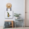 White Tote Bag with watercolor painting of a whimsical crow called Bubba the bag is haning on a wall