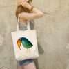 girl with a a white canvas tote bag featuring a watercolor painting of a whimsical crow