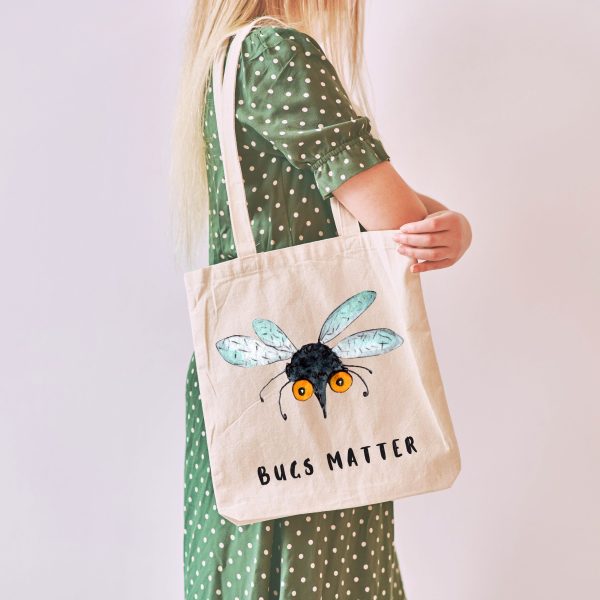 girl with a white canvas tote bag with a watercolor painting of a whimsical mosquito
