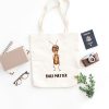 white canvas tote bag with a watercolor painting of a whimsical ant bag is on the floor