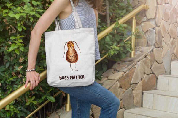 girl with a white canvas tote bag with a watercolor painting of a whimsical cockroach