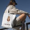 boy with a white canvas tote bag with a watercolor painting of a whimsical cockroach