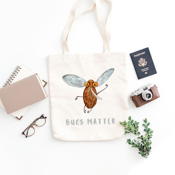 white canvas tote bag with a watercolor painting of a whimsical mosquito the bag is on the floor