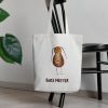 white canvas tote bag with a watercolor painting of a whimsical cockroach bag is hanging on a chair